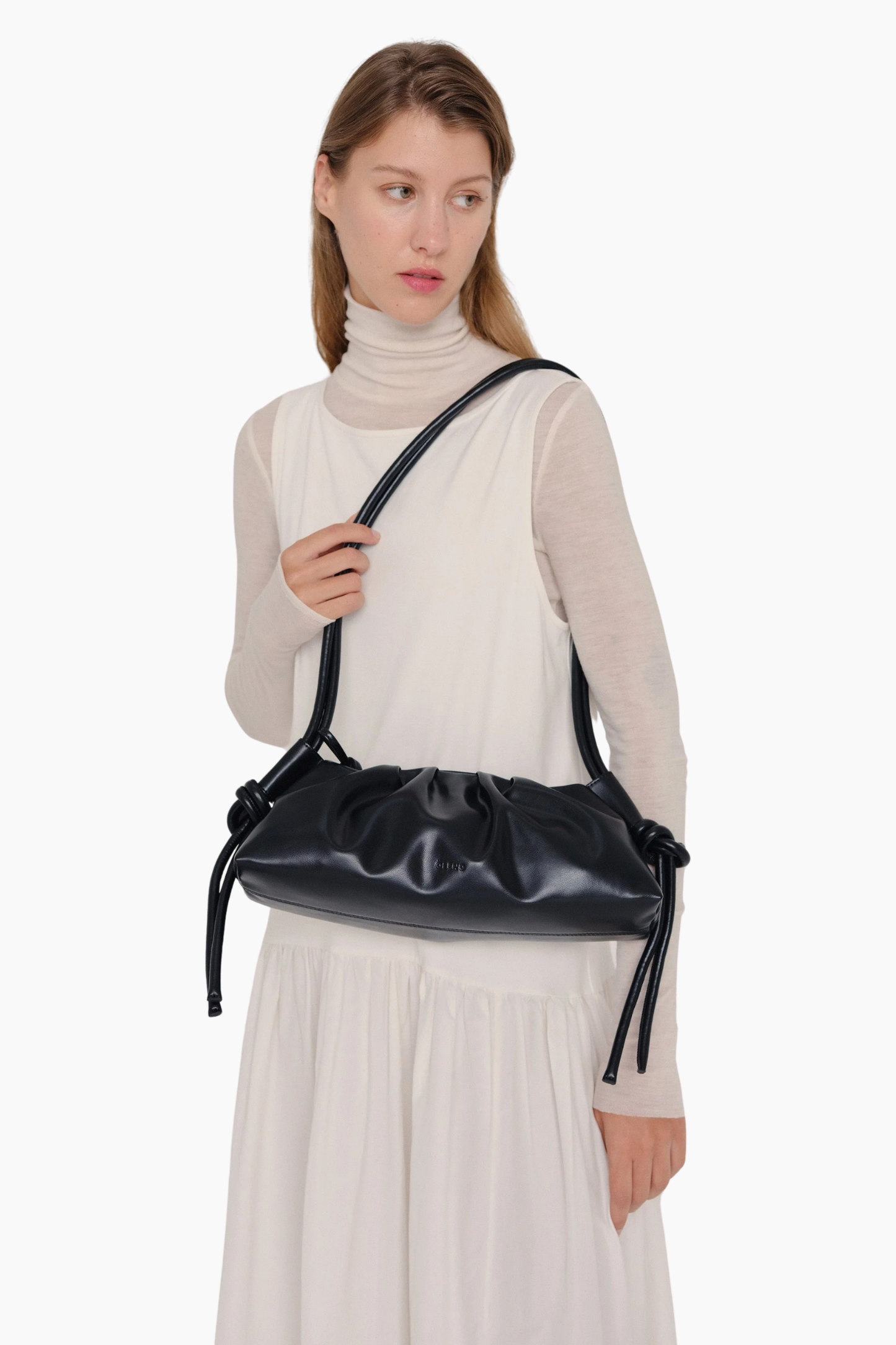 Bolso Dumpling negro de Ölend llevado al hombro con correa ajustable y diseño minimalista