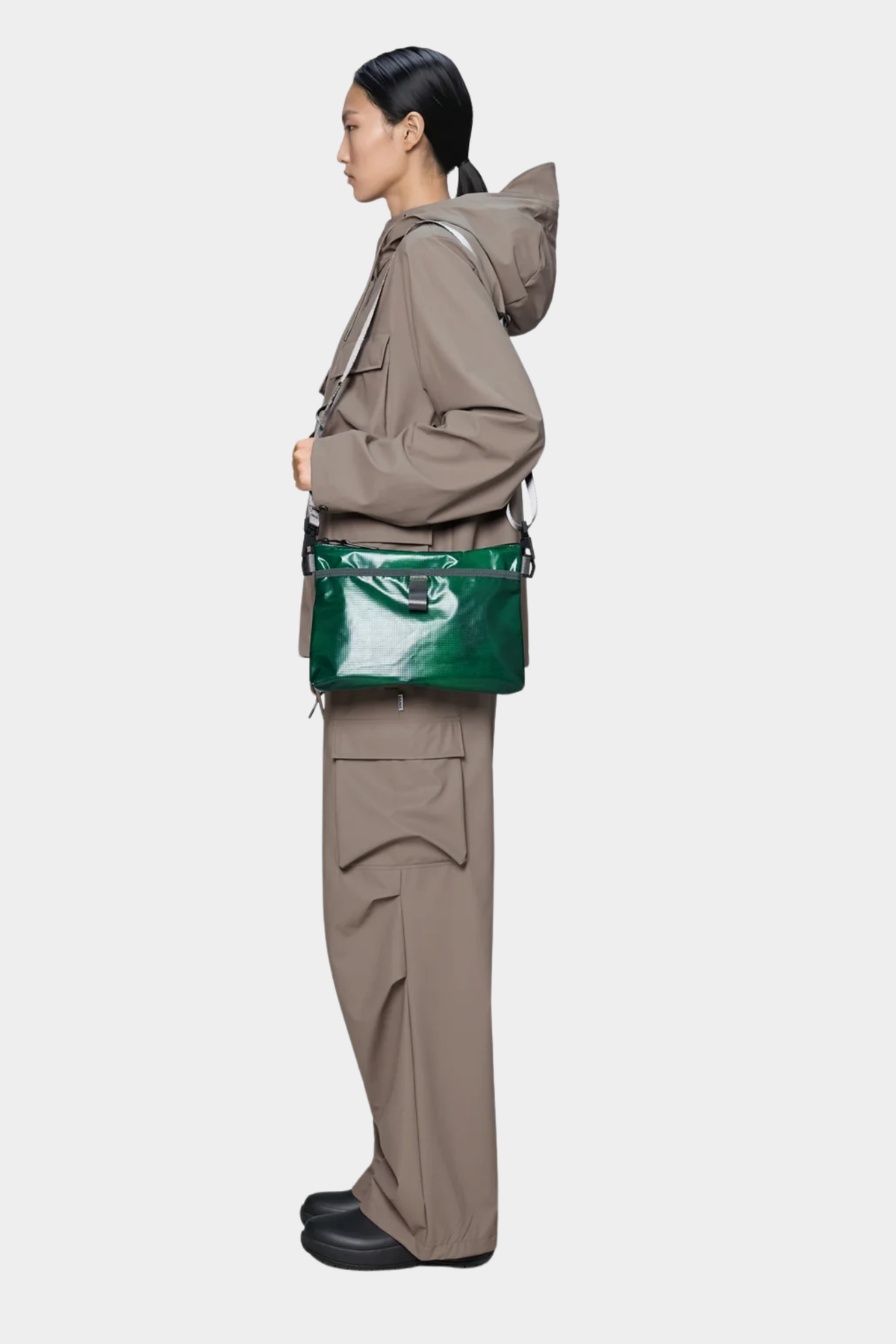 Bolso Rains Sibu Musette Envy llevado cruzado, con acabado verde brillante y formato ligero para diario