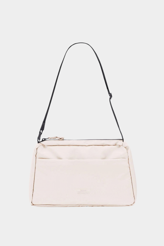 Bolso Ucon Acrobatics Emi Puffy Light Apricot acolchado, con correa ajustable y diseño compacto de 3 litros
