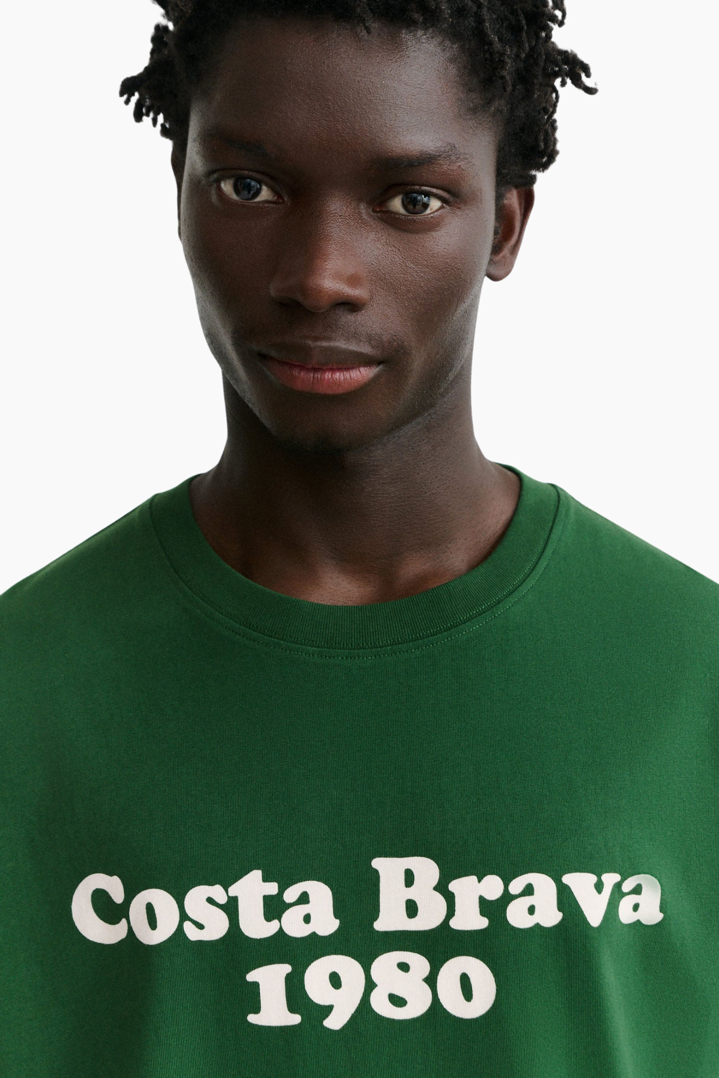 Detalle de camiseta verde Thinking Mu Costa Brava Aaron con estampado frontal Costa Brava 1980 de estilo retro