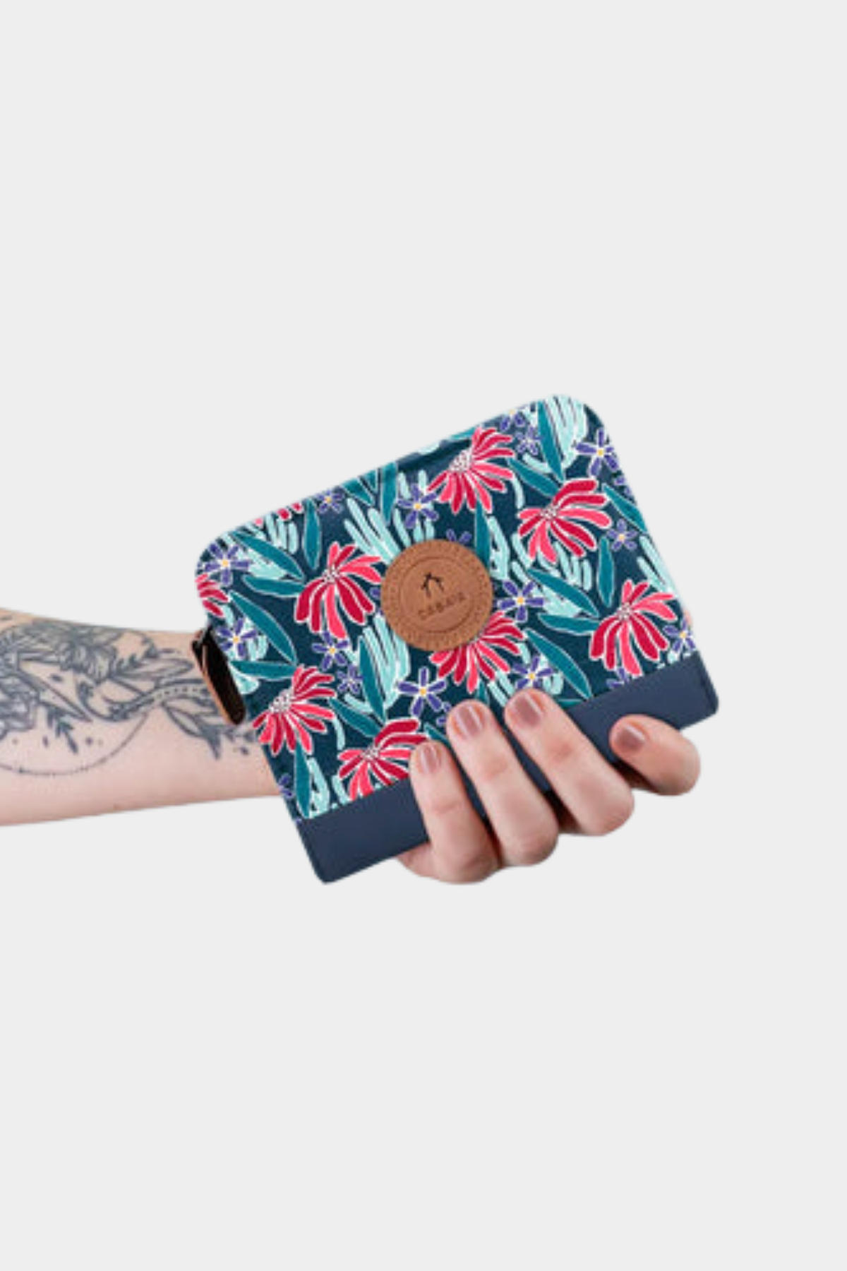 Cartera compacta Cabaia Small Edea mostrada en la mano con estampado floral azul y formato pequeño