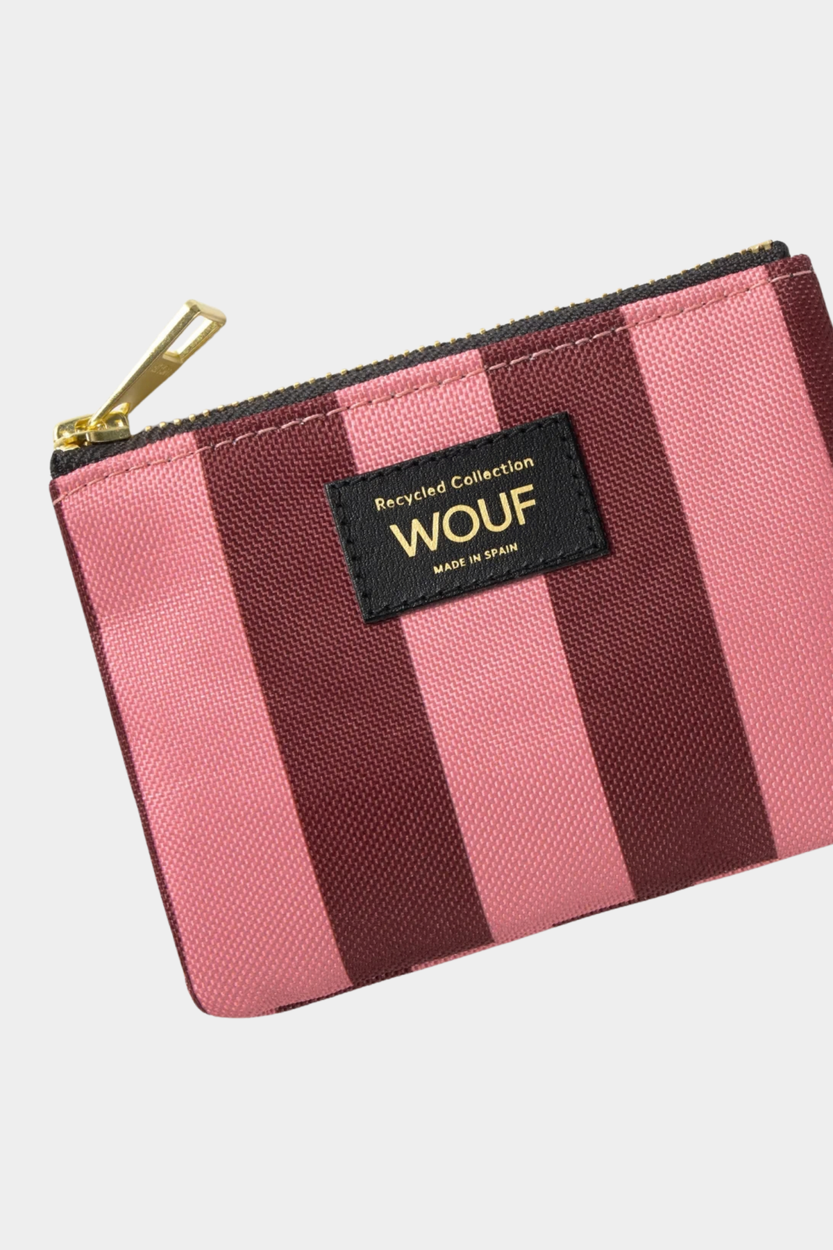 Detalle del monedero Wouf Sophie con estampado de rayas rosas y burdeos, etiqueta frontal y tirador dorado