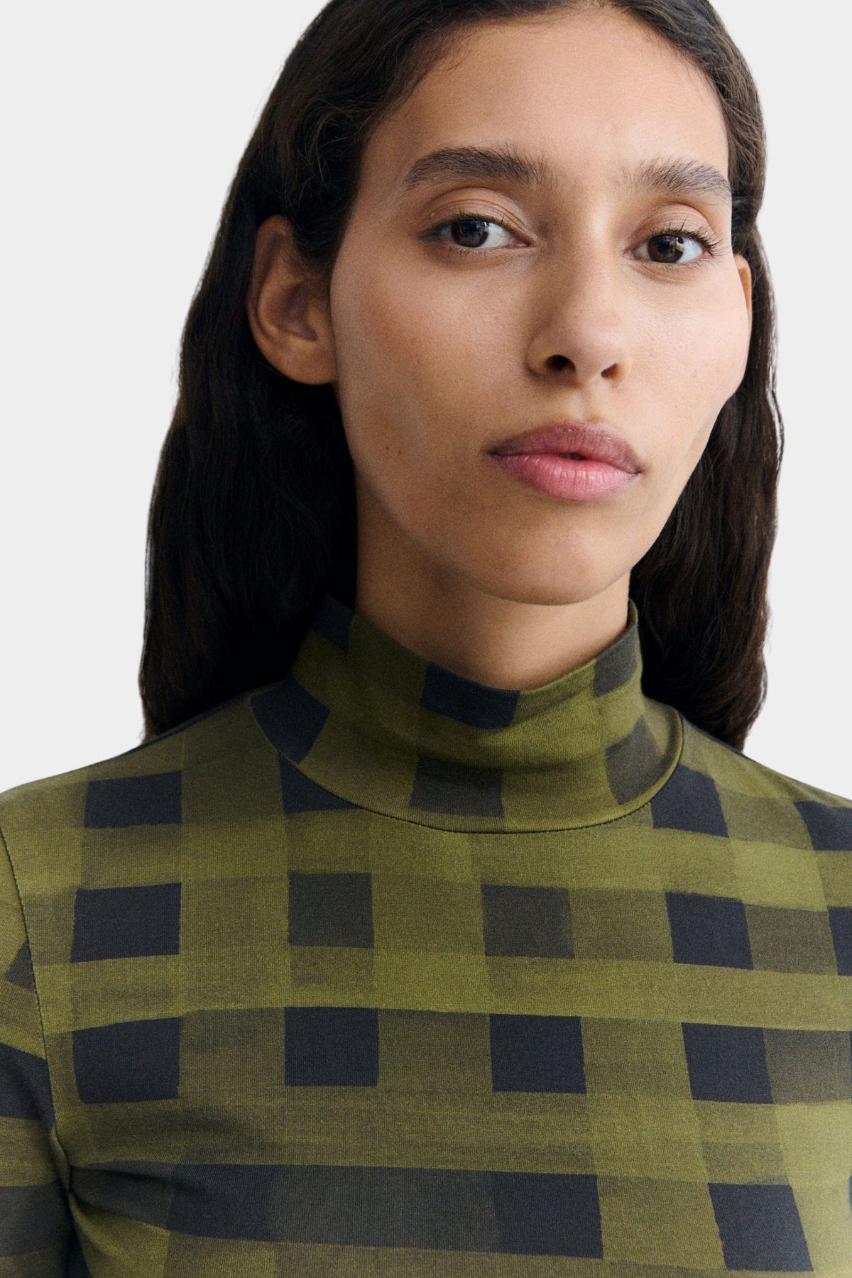 Detalle del top Ellen de Thinking Mu en algodón orgánico elástico con estampado verde y negro de cuadros