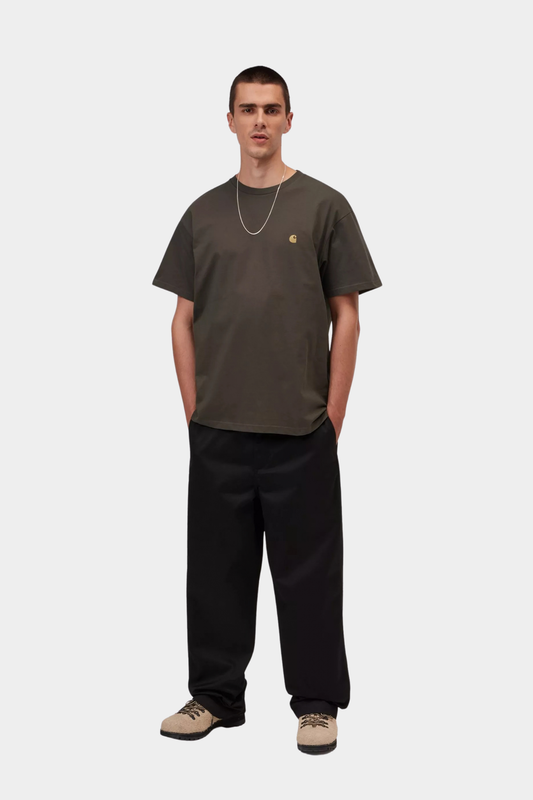 Look de hombre con camiseta Carhartt WIP S/S Chase Shungite, tono neutro oscuro con logo dorado bordado en el pecho