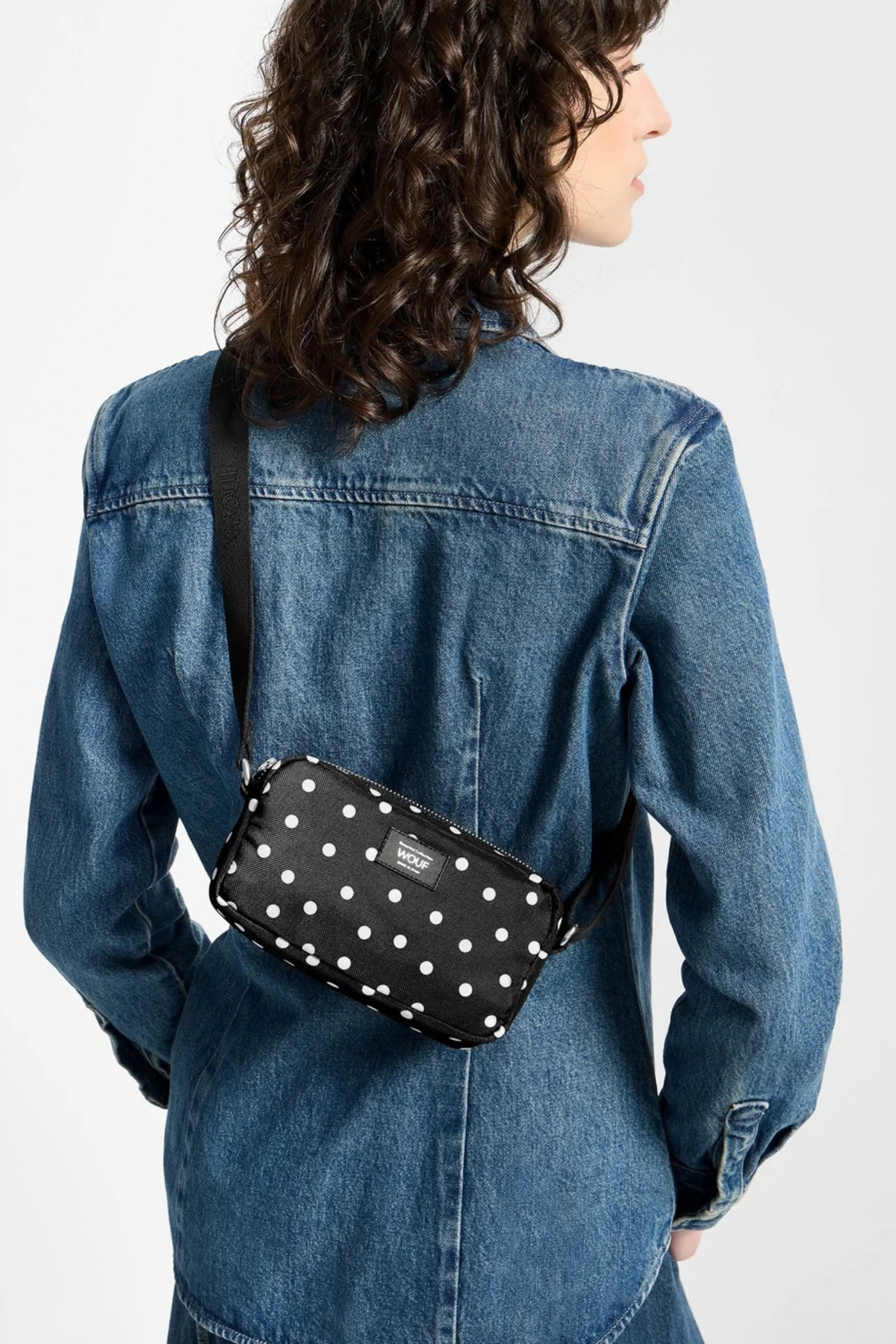 Mini bolso Wouf Grace llevado cruzado, con estampado de lunares blancos sobre negro y formato compacto