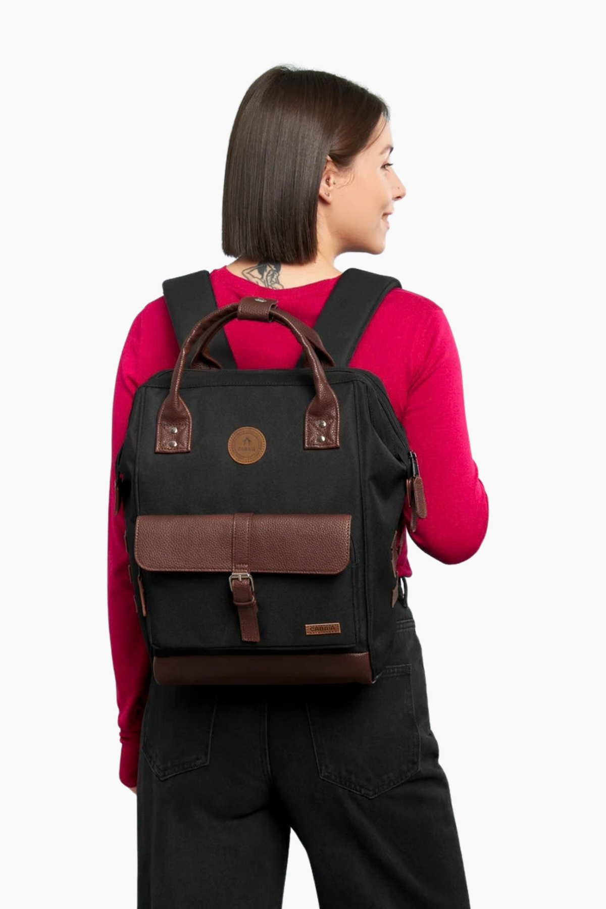 Mochila Cabaïa Adventurer Medium Managua negra puesta, tamaño 18 L con asas marrones y diseño urbano para diario