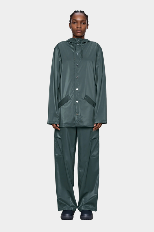 Rains Jacket Mystique unisex puesto, con tono verde azulado oscuro, capucha ajustable y corte regular