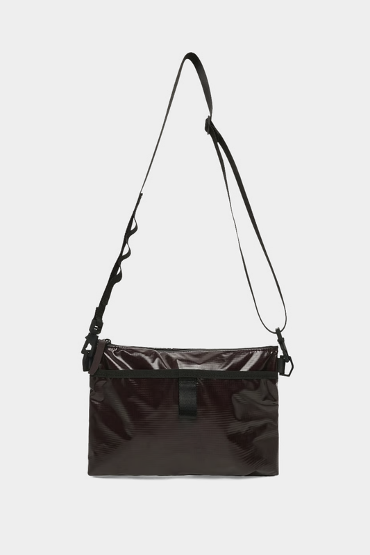 Detalle del bolso Rains Sibu Musette Bark con bolsillo frontal, cremallera revestida y acabado técnico marrón