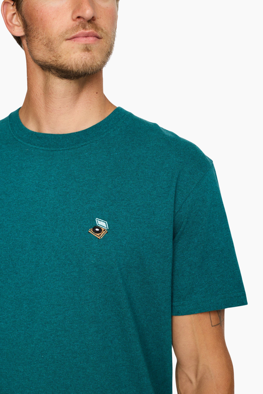 Detalle del pequeño bordado multicolor en el pecho de la camiseta Petrol 1449 PLA de Revolution para hombre