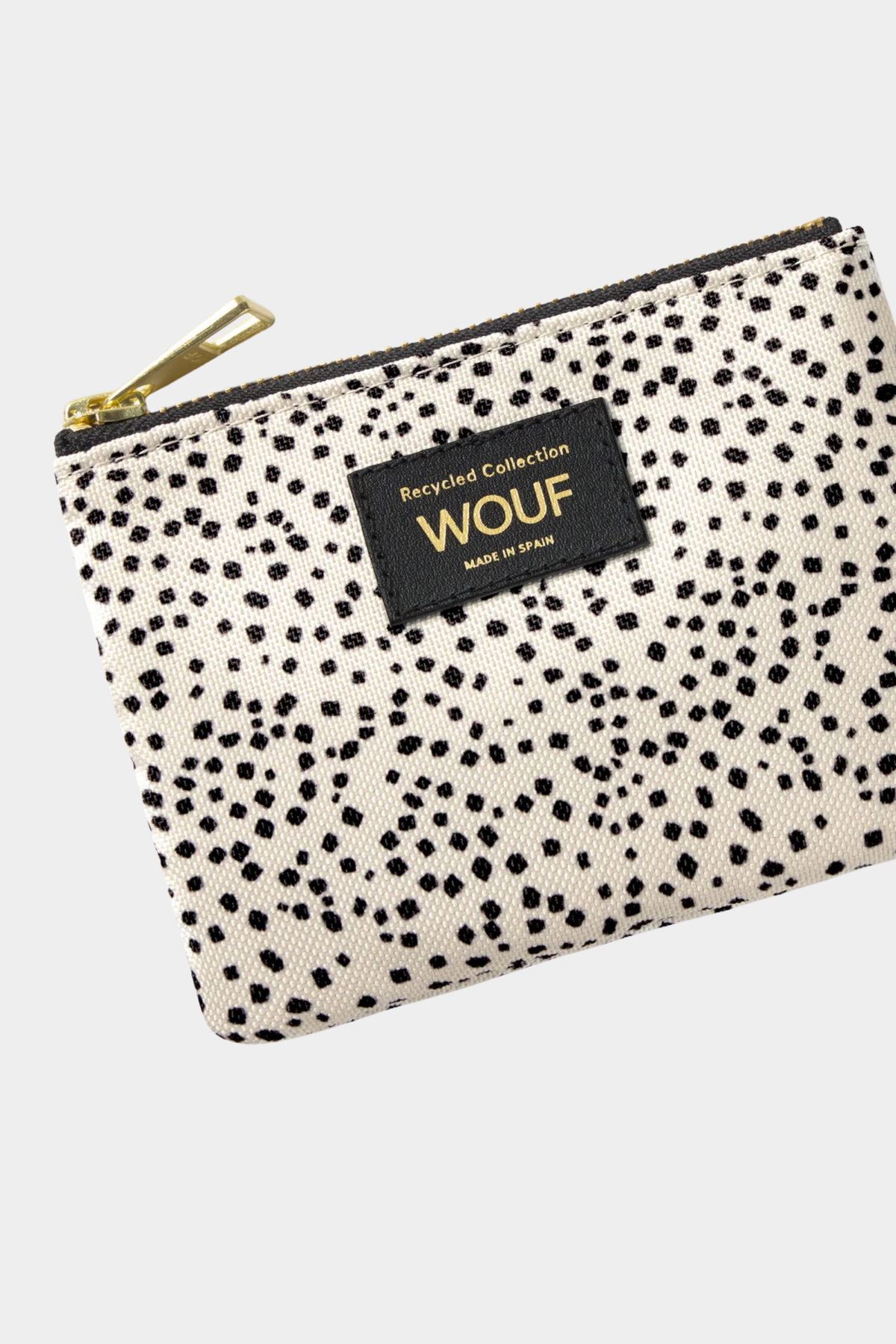 Detalle del monedero Wouf Panna con microestampado beige y negro, etiqueta frontal y tirador dorado