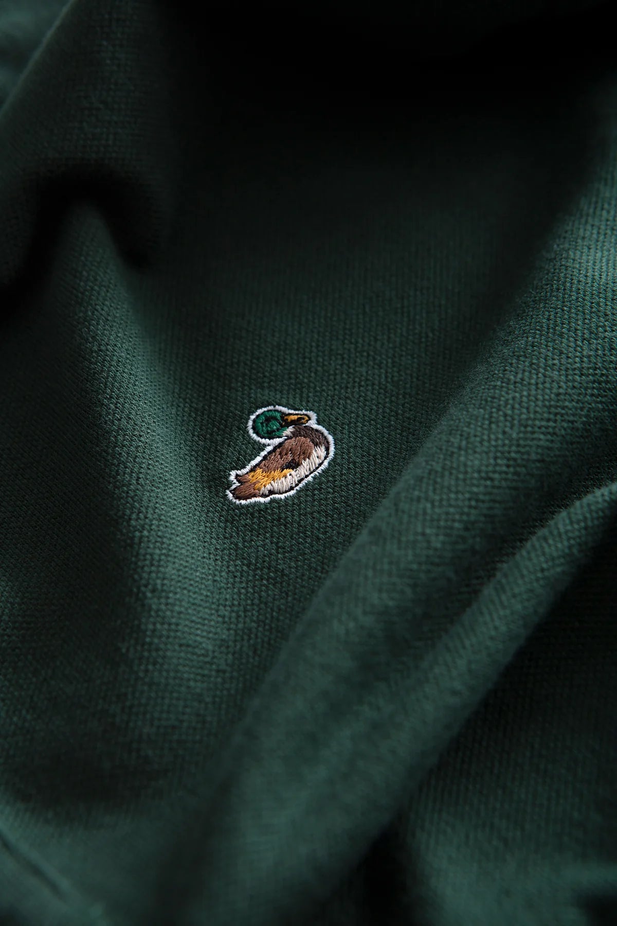 Detalle del pato bordado en el pecho del Duck Polo verde de hombre Edmmond Studios en algodón orgánico