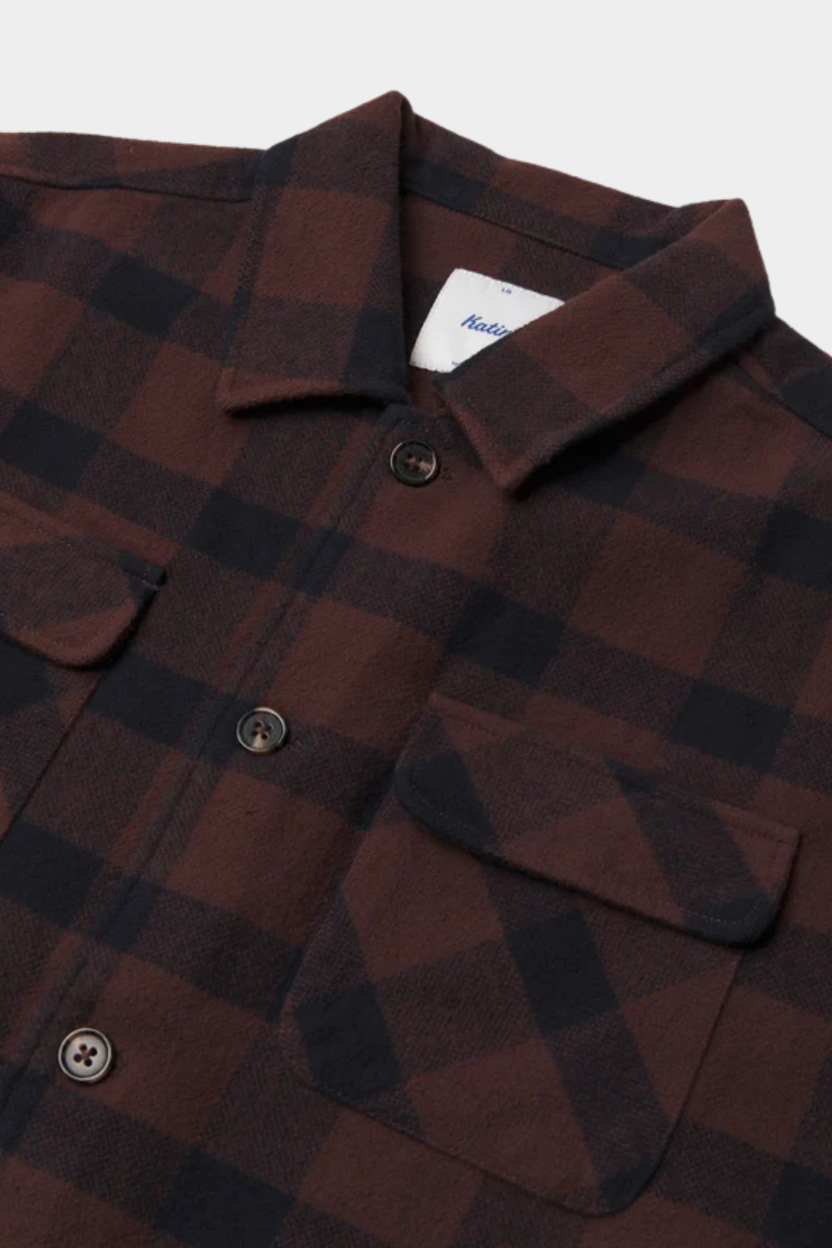 Detalle de la sobrecamisa Shiloh de Katin USA con franela cepillada, cuadros marrón y azul y bolsillos con solapa