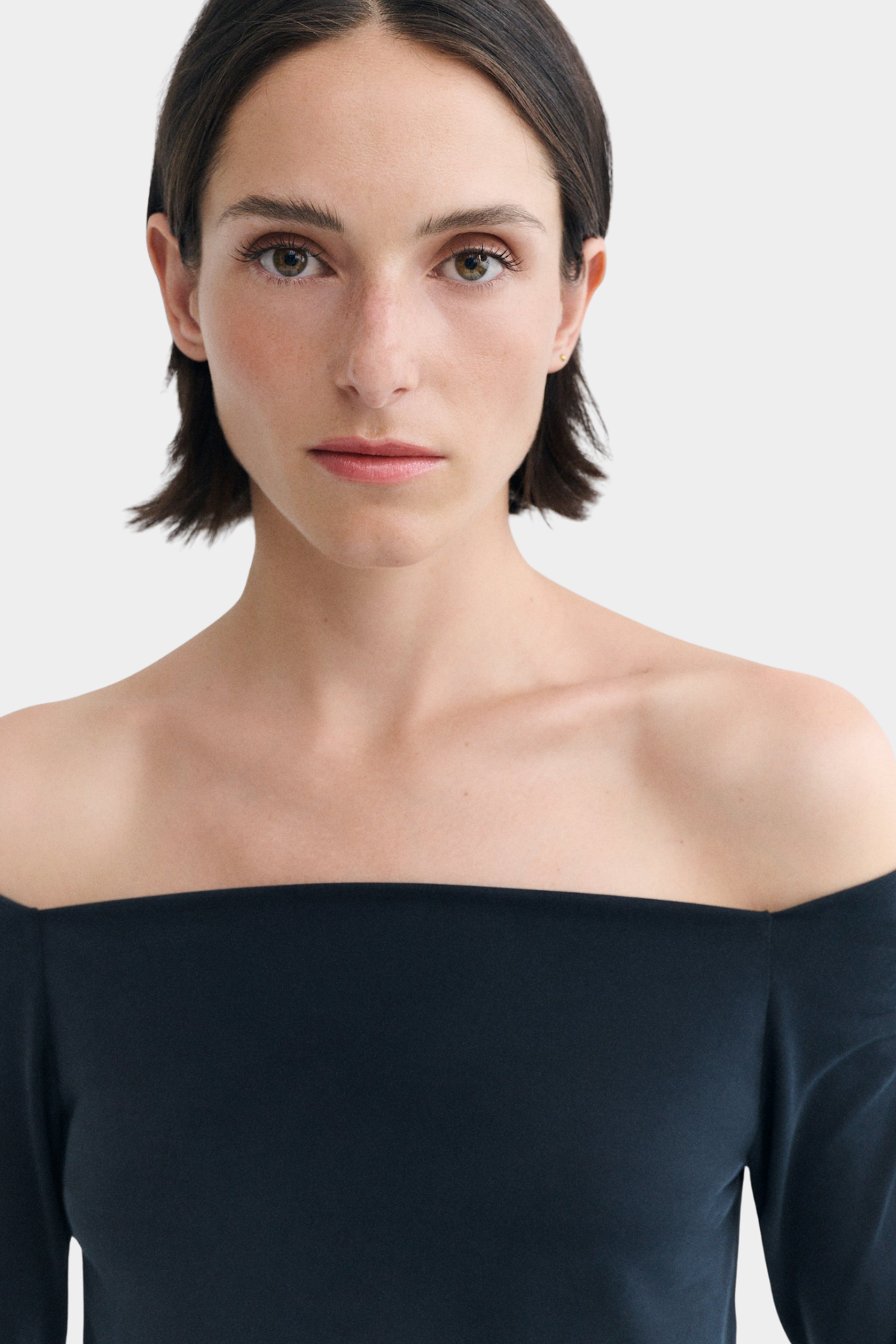 Detalle del top Berta negro de Thinking Mu en modal jersey suave, con escote off shoulder y manga larga