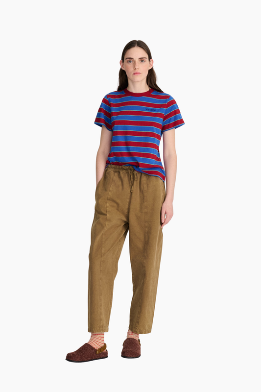 Look de mujer con camiseta cropped de rayas azules y rojas Bobo Choses combinada con pantalón marrón