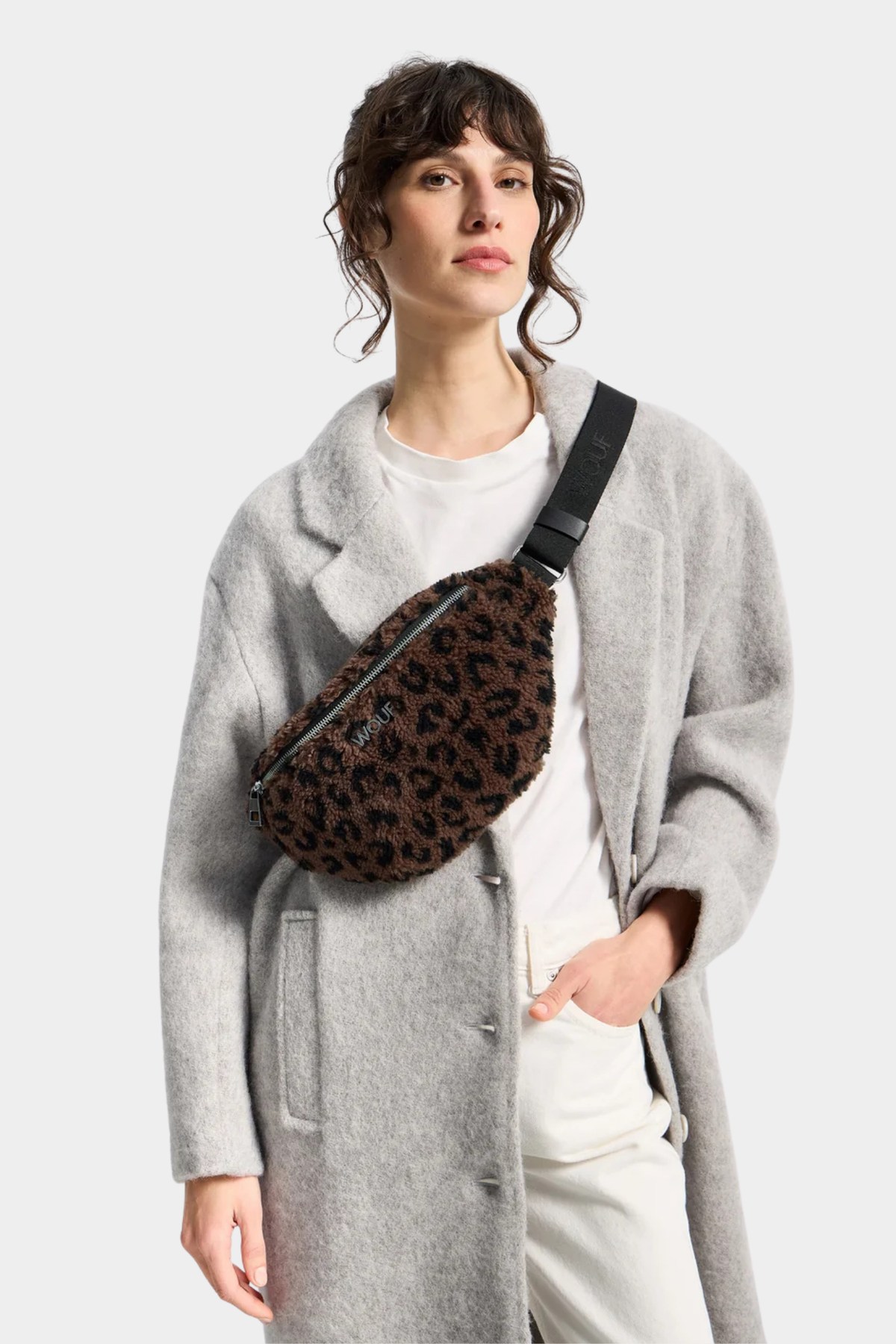 Riñonera Romy de Wouf llevada cruzada al pecho, con textura teddy y estampado leopardo en tonos marrón y negro