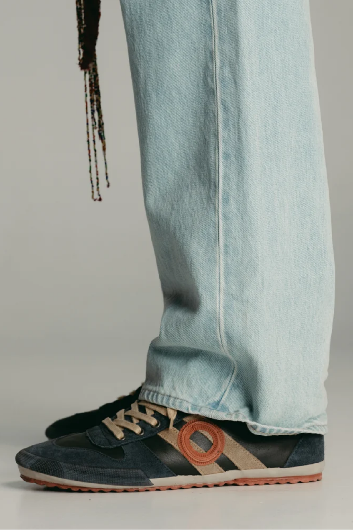 Zapatillas Aro Ido Wash Midnight puestas con vaqueros, diseño unisex de perfil bajo y estética retro